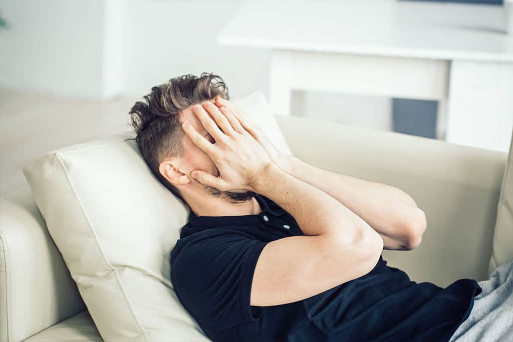 Terapia &ndash; droga do zmiany siebie - zmartwiony mężczyzna siedzi na kanapie - artykuł Marity Woźny