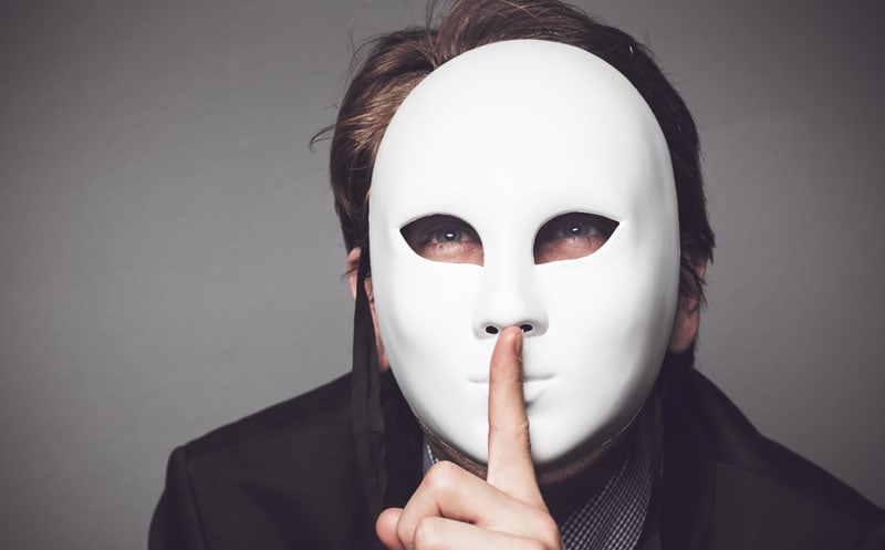 Maski i role przyjmowane w dzieciństwie - młody chłopak skryty za białą maską - artykuł Marity Woźny