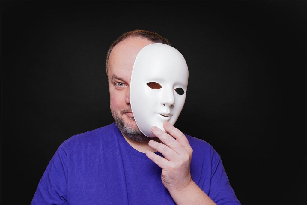 Syndrom DDA, współuzależnienie i moja tożsamość – jak ją znaleźć? - mężczyzna zdejmuje maskę z twarzy - artykuł Marity Woźny