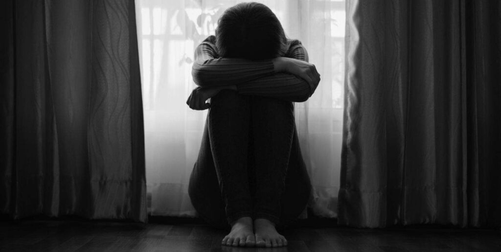 Kryzys w Związku - 3 trzy lęki, które prowadzą do kryzysu w związku - ktoś siedzi na łóżku smutny i załamany - artykuł Marity Woźny