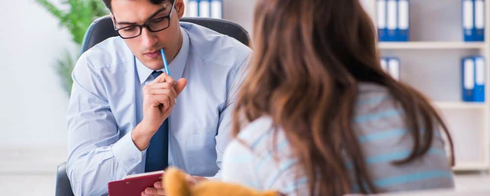 Do kogo po pomoc - psycholog, psychoterapeuta czy psychiatra? - psychiatra słucha uważnie swojej pacjentki, która siedzi naprzeciw niego - psychoterapeuta Wrocław Marita Woźny