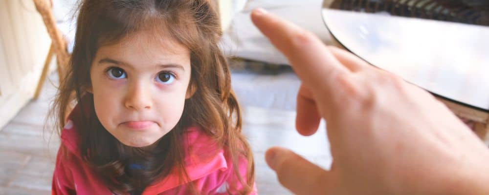 Przemoc domowa i przemoc psychiczna wobec dzieci – jak ją rozpoznać i przerwać? - smutna dziewczynka smutna dziewczynka patrzy na ojca, który unieważnia jej emocje - blog Marita Woźny
